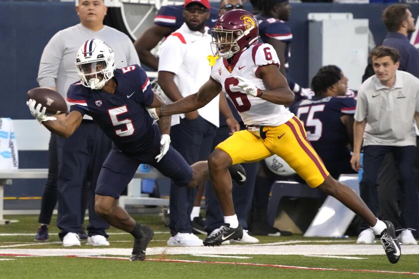Arizona receiver Dorian Singer hauls in a pass in front of a USC player last season