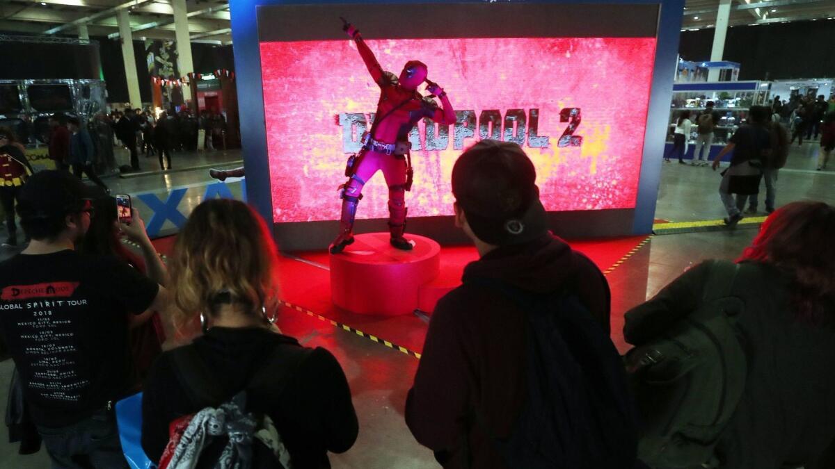 Visitors take photos of a promotional stand for "Deadpool 2" during Comic Con Chile 2018 in May.