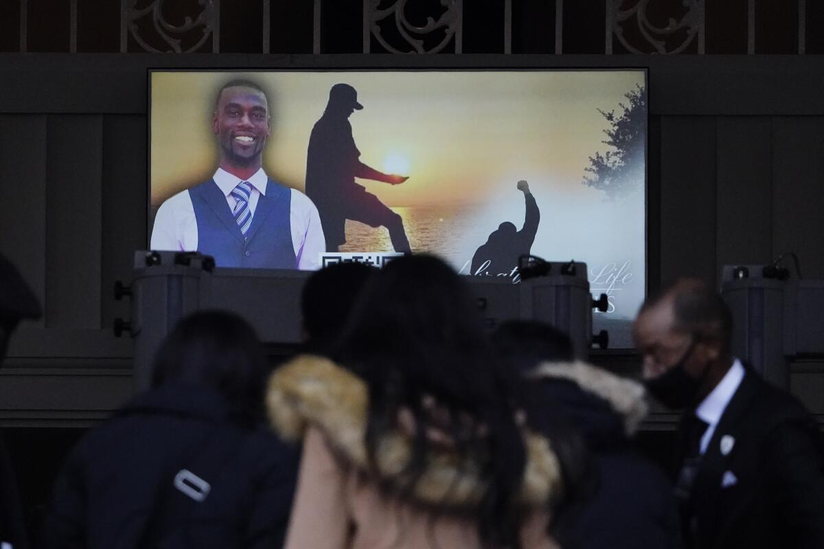 Images of Tyre Nichols are seen at his funeral service as people gather.