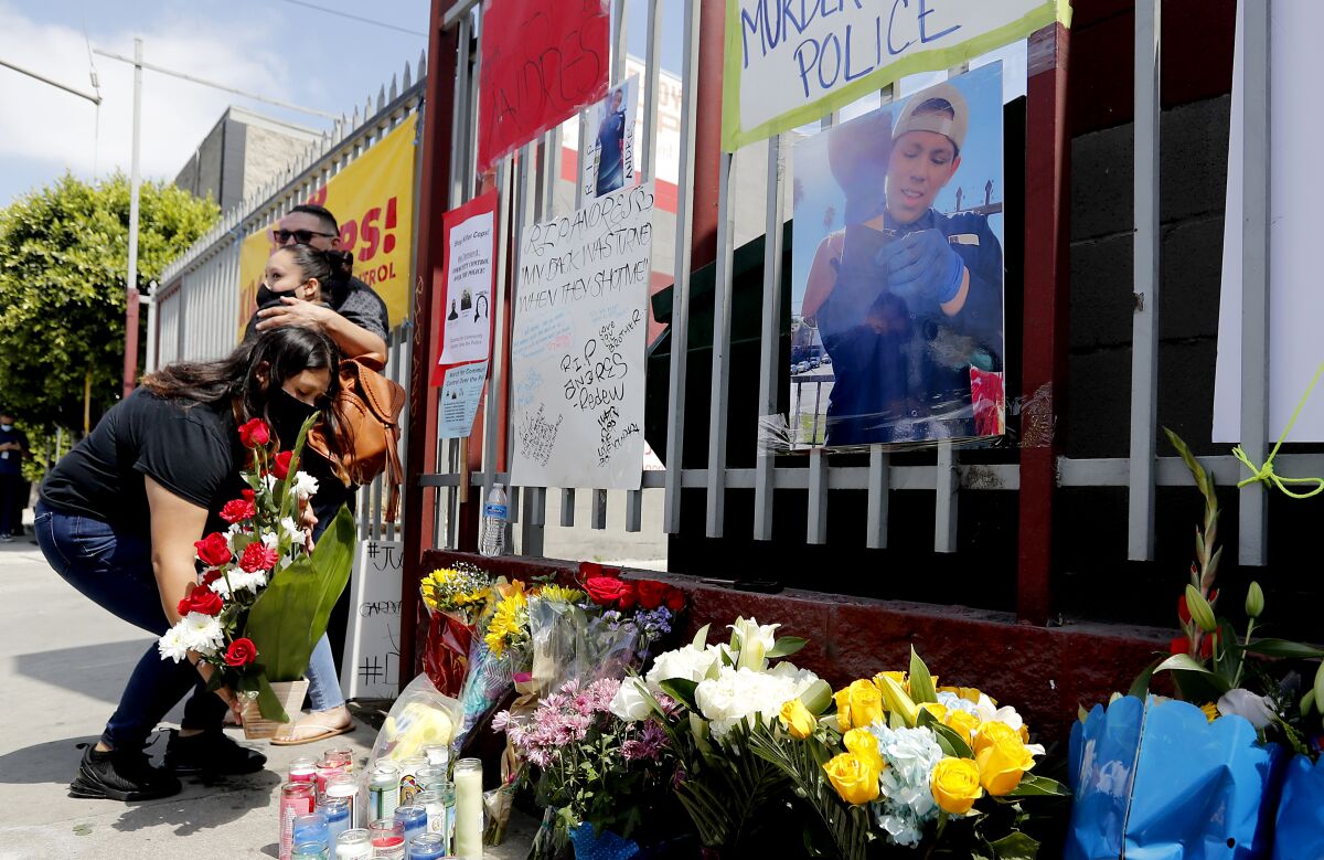 Family and friends leave candles and flowers at the auto body shop in Gardena, near where Andres Guardado was killed