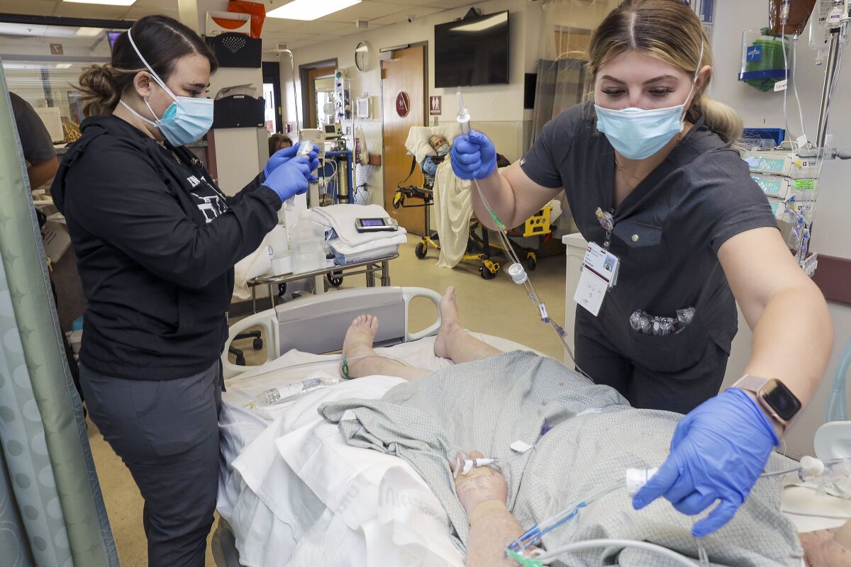 Nurses Amber McCarter Rebekah Seyler attend to a COVID-19 patient.