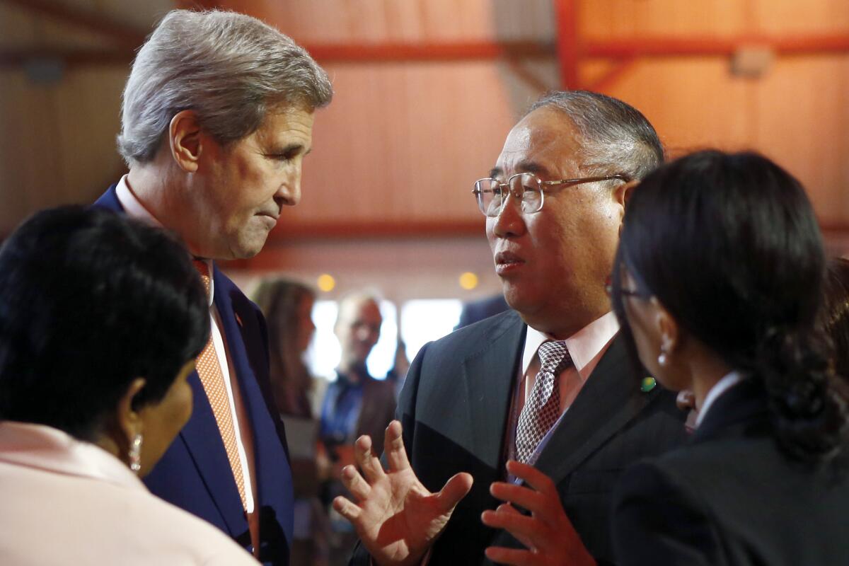 U.S. Secretary of State John F. Kerry, left, talks with China's special representative on climate change Xie Zhenhua prior to the opening of the COP21 conference in Le Bourget, France on Saturday.