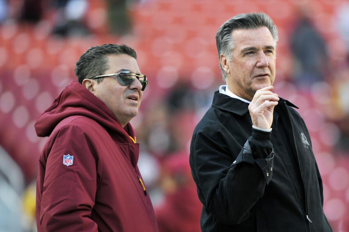 Washington Redskins owner Dan Snyder and team president Bruce Allen talk on the field prior to a 2018 NFL game 