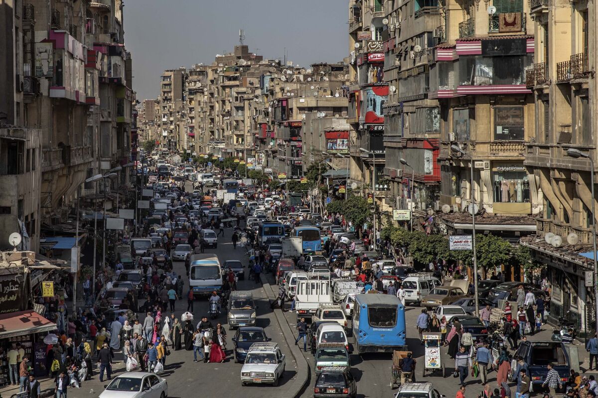 FILE - People crowd a street a few hours ahead of curfew in Cairo, Egypt, Tuesday, April 14, 2020. Egypt's annual inflation surged to a new high in January, as Egyptians continue to battle ongoing price hikes and a depreciating currency, the country’s statistics bureau said Thursday. (AP Photo/Nariman El-Mofty, File)