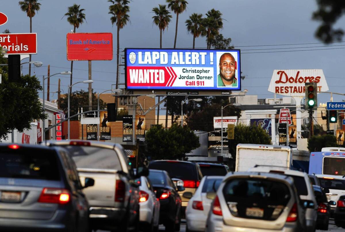 A digital billboard along Santa Monica Boulevard displays a "wanted" alert for former Los Angeles police officer Christopher Dorner