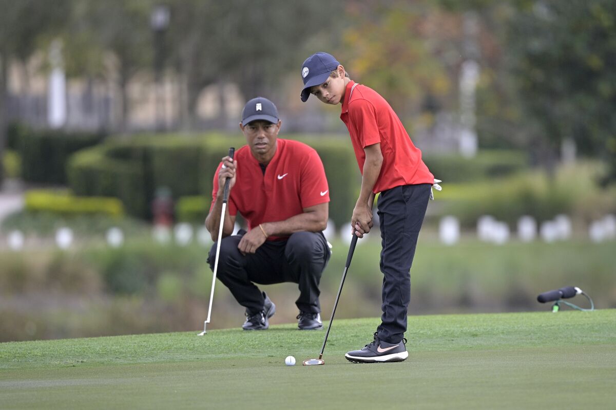 Tiger Woods watches his son Charlie putt at a tournament in December.