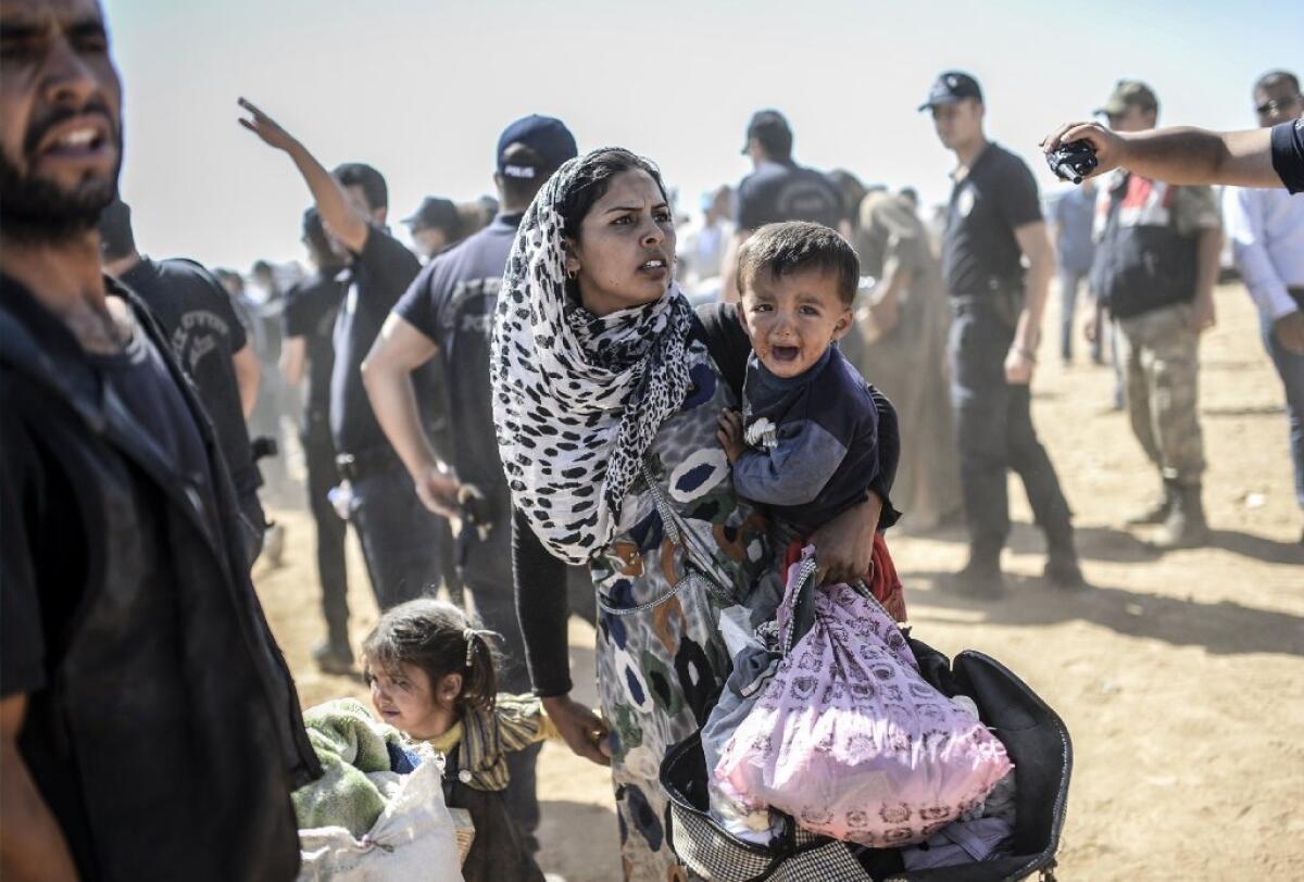 A Syrian Kurdish woman crosses the border between Syria and Turkey at the southeastern town of Suruc in September.