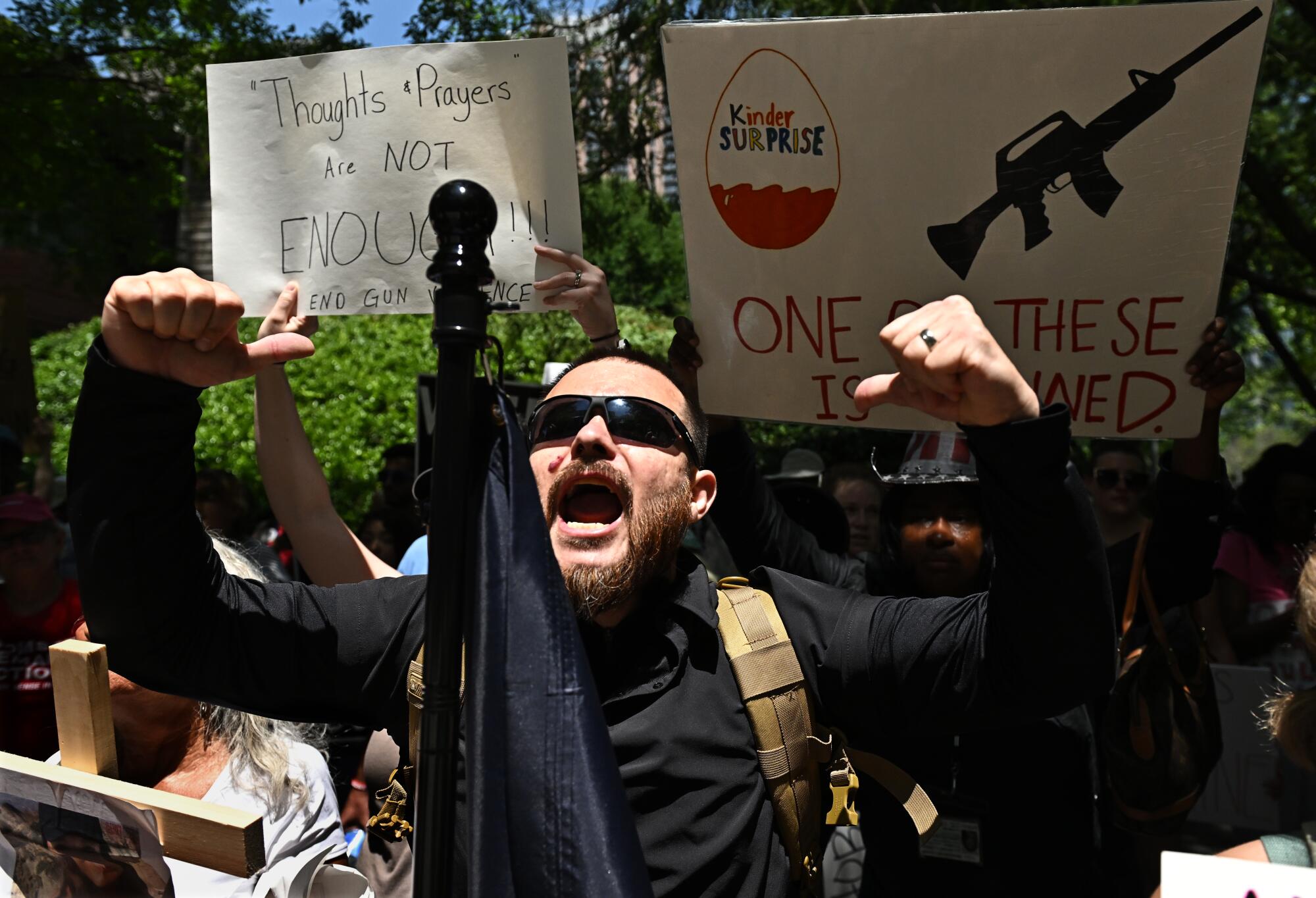 Protestors shout while holding signs