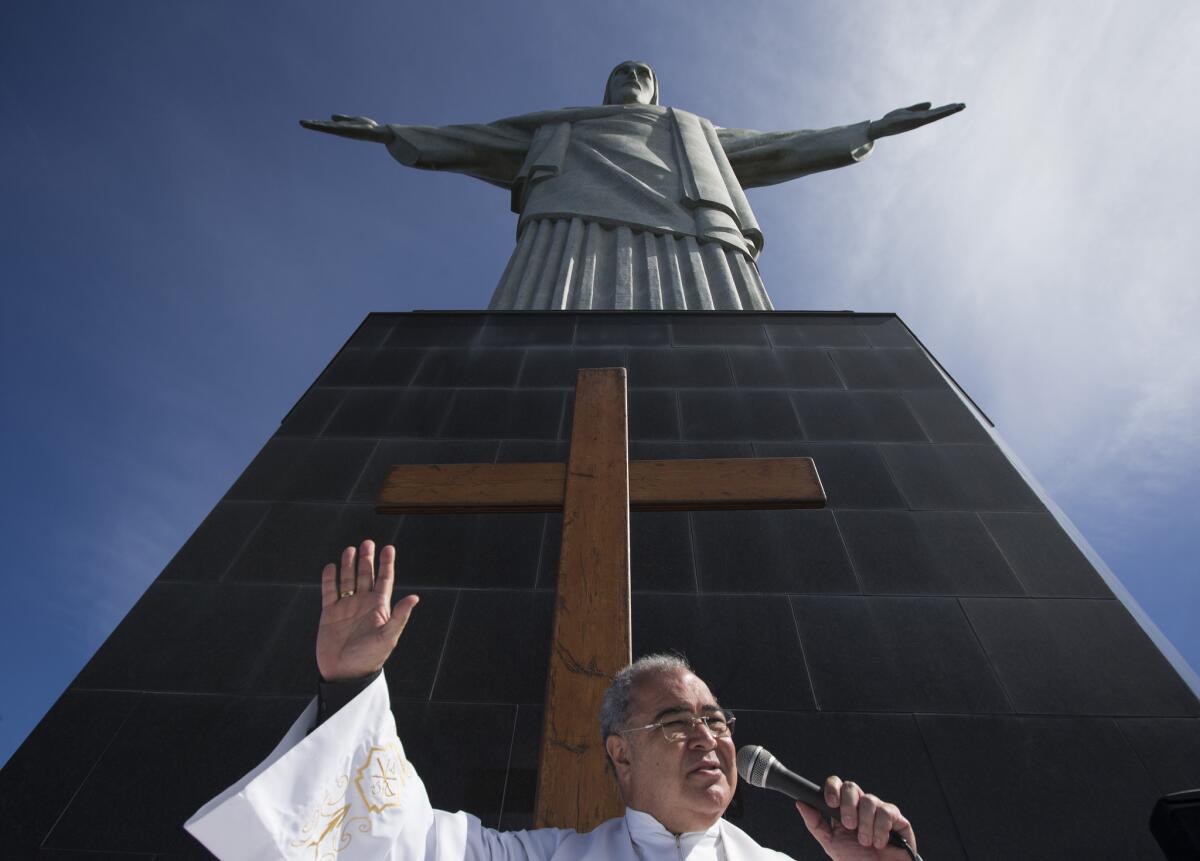 In this July 12, 2013, file photo, Archbishop Orani Joao Tempesta of Rio de Janeiro is among 19 new cardinals named by Pope Francis on Sunday. Above, Tempesta gives a sermon last summer in front of the World Youth Day cross and the Christ Redeemer statue in Rio.
