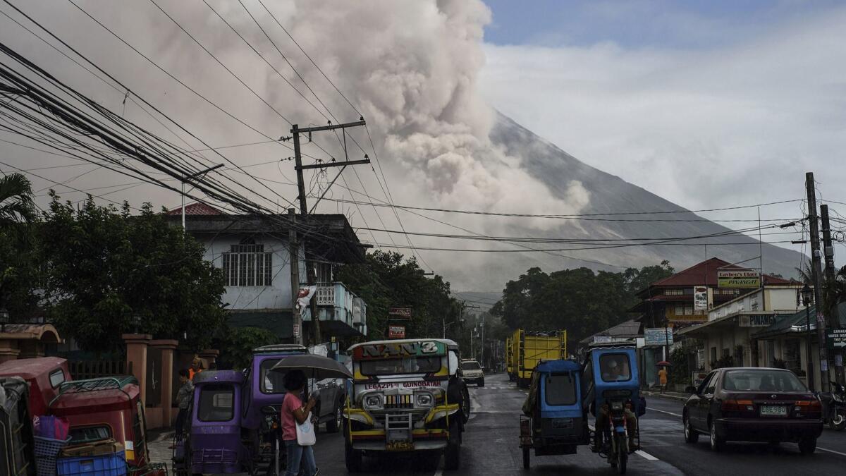 The erupting volcano at Mt. Mayon sends smoke and ash into the air near the Philippine town of Camalig on Jan. 22.