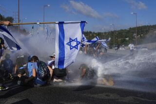 La policía israelí utiliza un cañón de agua para dispersar a los manifestantes que bloqueaban una autopista a Jerusalén, durante protestas contra los planes de reforma judicial del gobierno del primer ministro, Benjamin Netanyahu, el martes 11 de julio de 2023. (AP Foto/Ohad Zwigenberg)