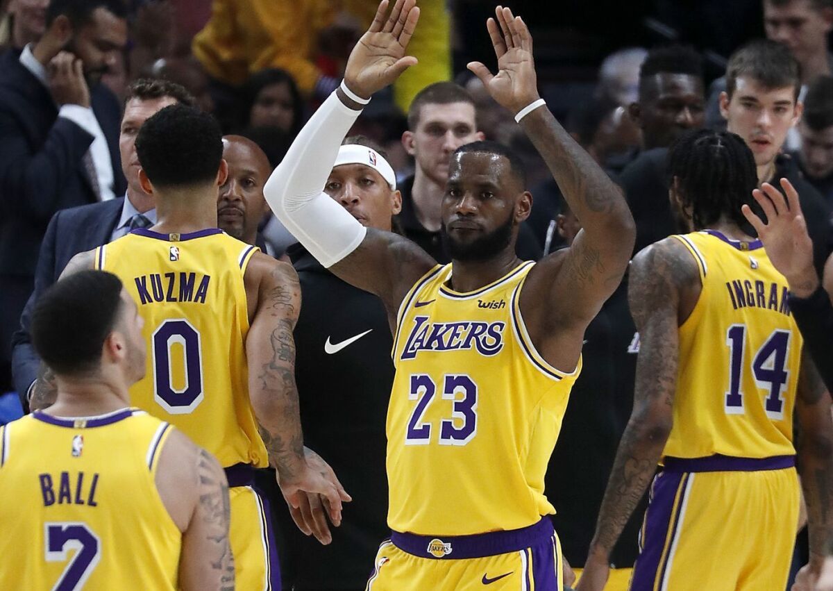 LeBron James celebrates with Lakers teammates during their Oct. 18 season operner in Portland.