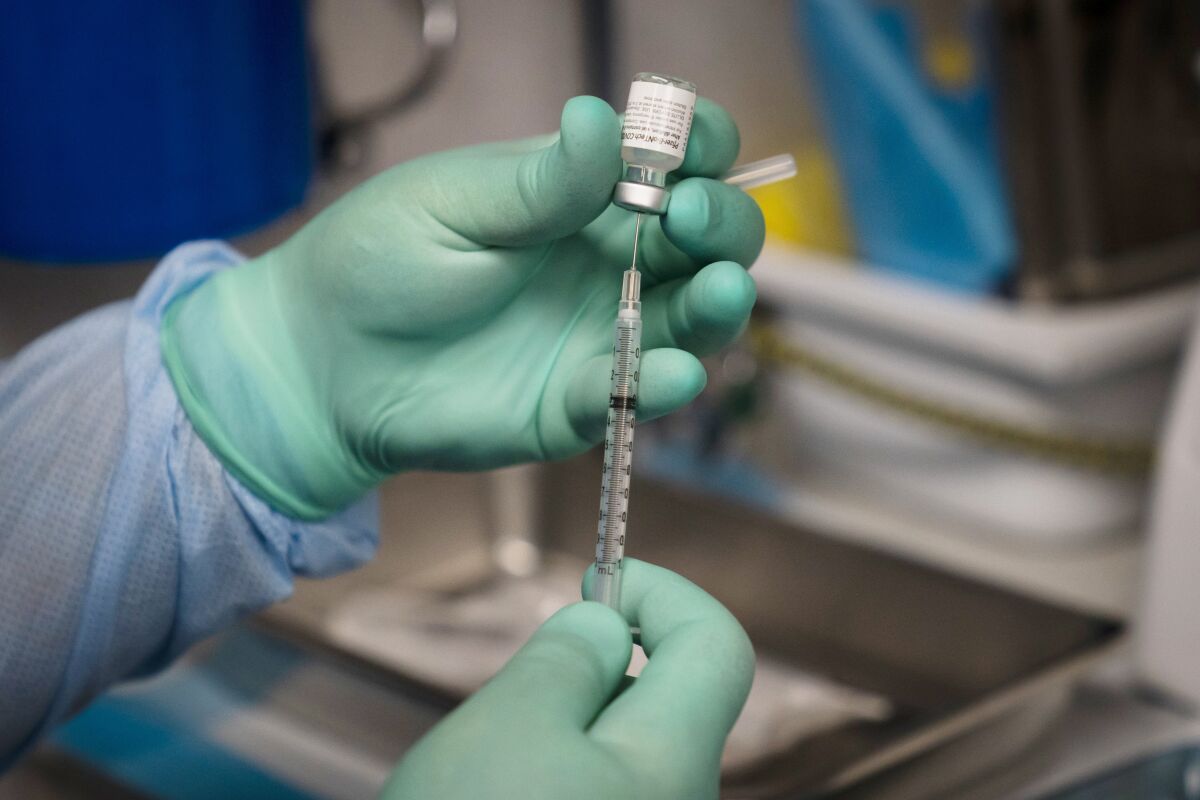 A syringe is prepared with the Pfizer COVID-19 vaccine. 