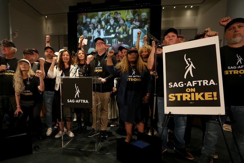 Los Angeles, CA - Members of the SAG-AFTRA union raise their fists after declaring a strike at a press confernece in union headqaurter in Los Angeles on Thursday, July 12, 2023. (Luis Sinco / Los Angeles Times)