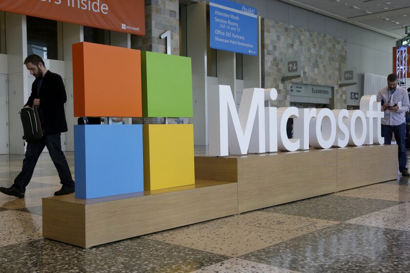 FILE - A man walks past a Microsoft sign set up for the Microsoft BUILD conference, April 28, 2015, at Moscone Center in San Francisco. Microsoft will pay a fine of $20 million to settle Federal Trade Commission charges that it illegally collected and retained the data of children who signed up to use its Xbox video game console. (AP Photo/Jeff Chiu, File)