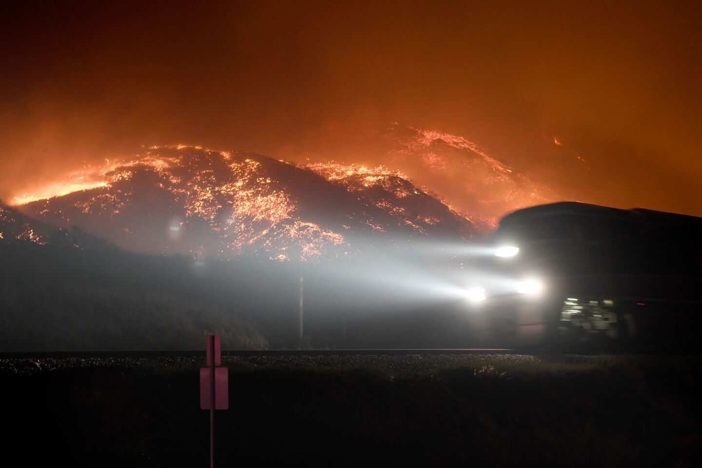 A train on the Rincon coast passes a burning hillside from the Thomas fire.