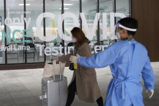 FILE - A woman arriving from China enters a COVID-19 testing center at the Incheon International Airport In Incheon, South Korea, Thursday, Jan. 5, 2023. China suspended visas Tuesday for South Koreans to come to the country for tourism or business in apparent retaliation for COVID-19 testing requirements on Chinese travelers. (AP Photo/Lee Jin-man, File)
