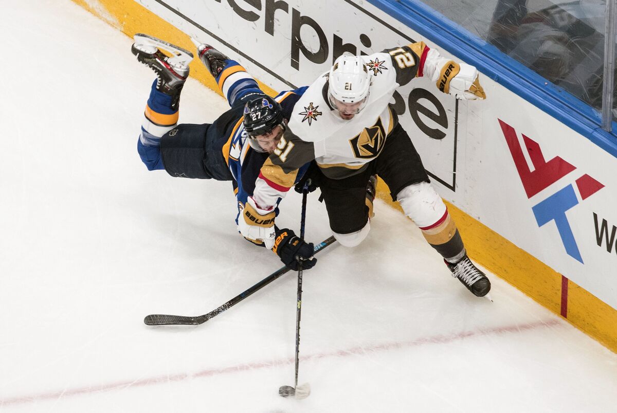 St. Louis Blues' Alex Pietrangelo (27) and Vegas Golden Knights' Nick Cousins (21) battle for the puck during the second period of an NHL hockey playoff game Thursday, Aug. 6, 2020, in Edmonton, Alberta. (Jason Franson/Canadian Press via AP)