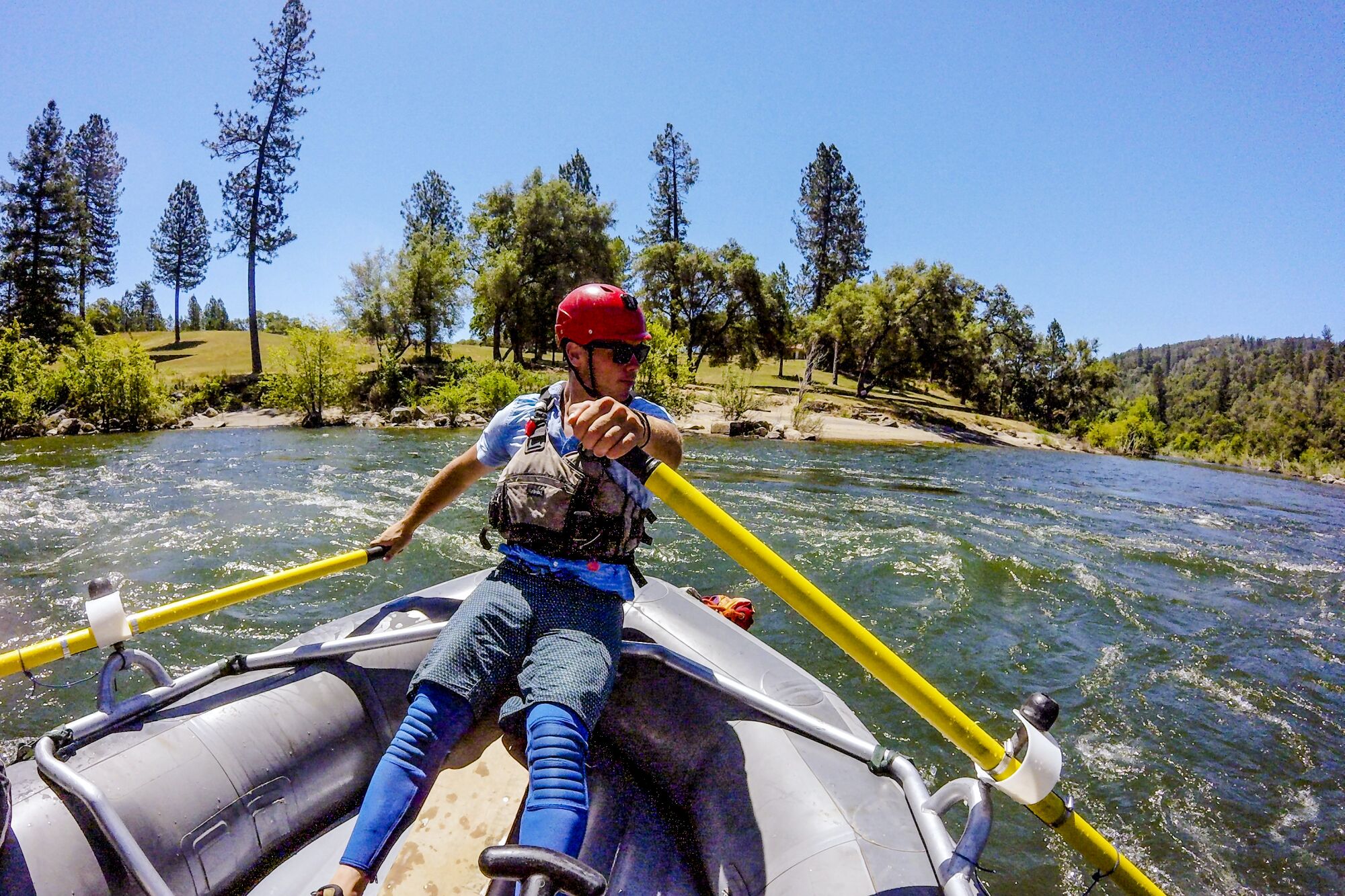 River guide Kyle Brazil uses oars to steer and propel an inflatable raft in the American River. 