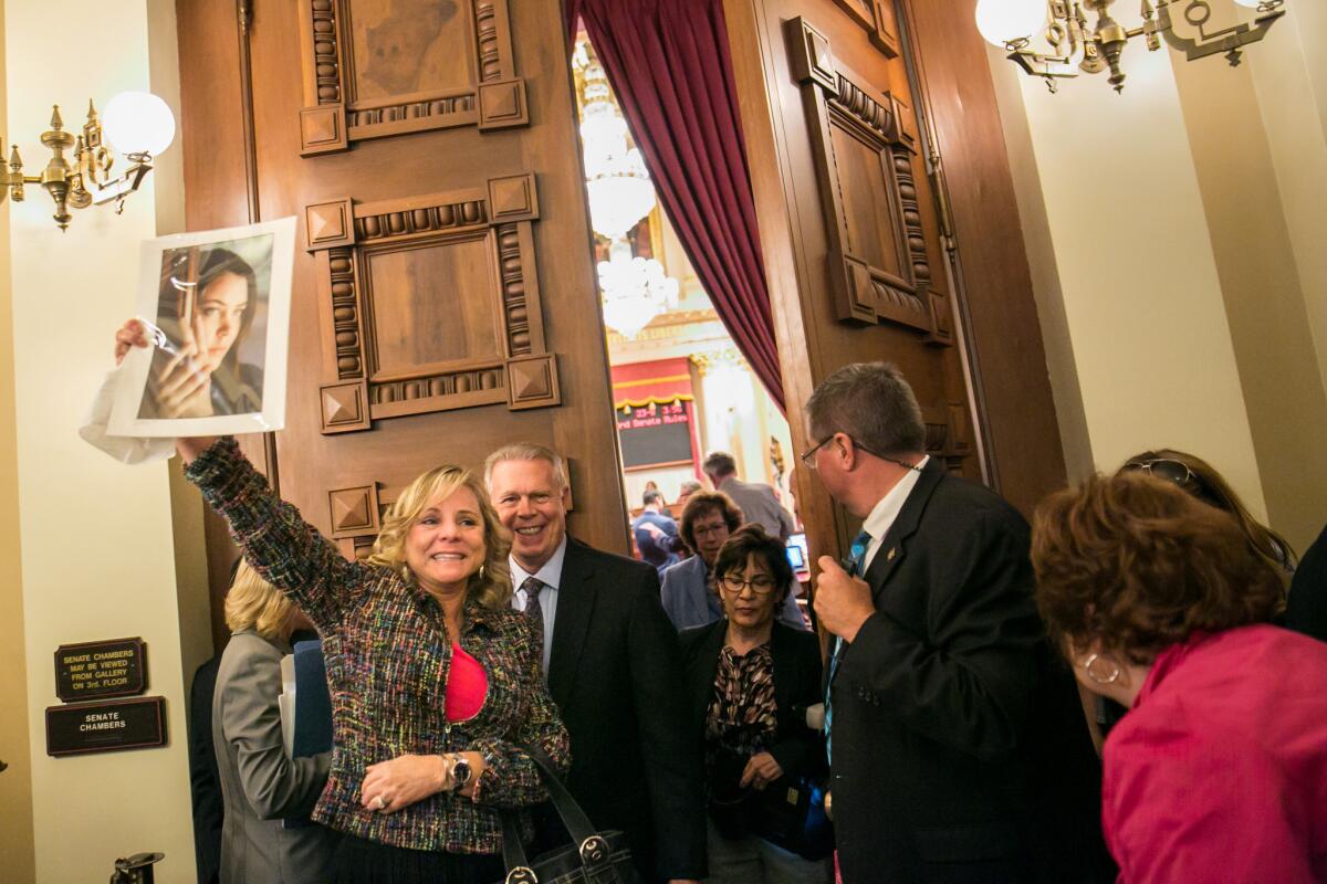 Debbie Ziegler, who supported the assisted-death law, holds up a photograph of her daughter Brittany Maynard after the senate voted and approved the passage of the aid-in-dying legislation on the senate floor, in Sacramento on Sept. 11, 2015.