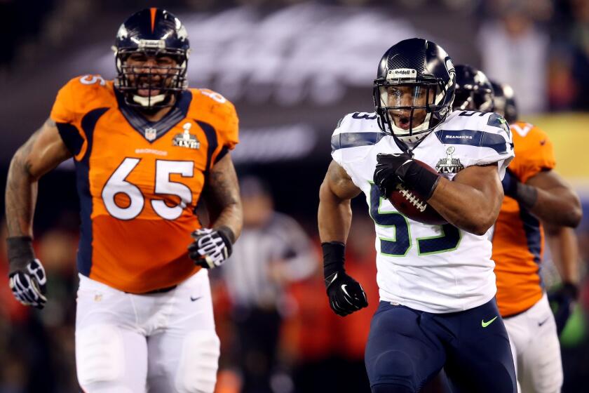 Seattle linebacker Malcolm Smith leaves Denver lineman Louis Vasquez (65) in his wake on a 69-yard interception return for a touchdown in the second quarter.