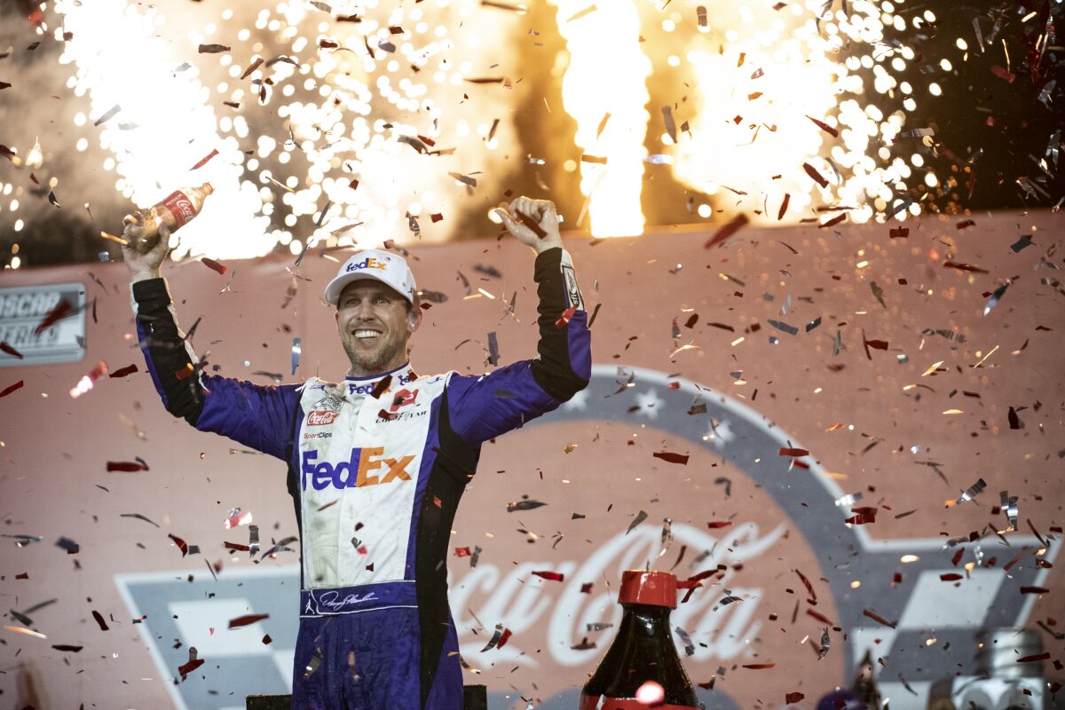 Denny Hamlin celebrates in Victory Lane after winning a NASCAR Cup Series auto race.