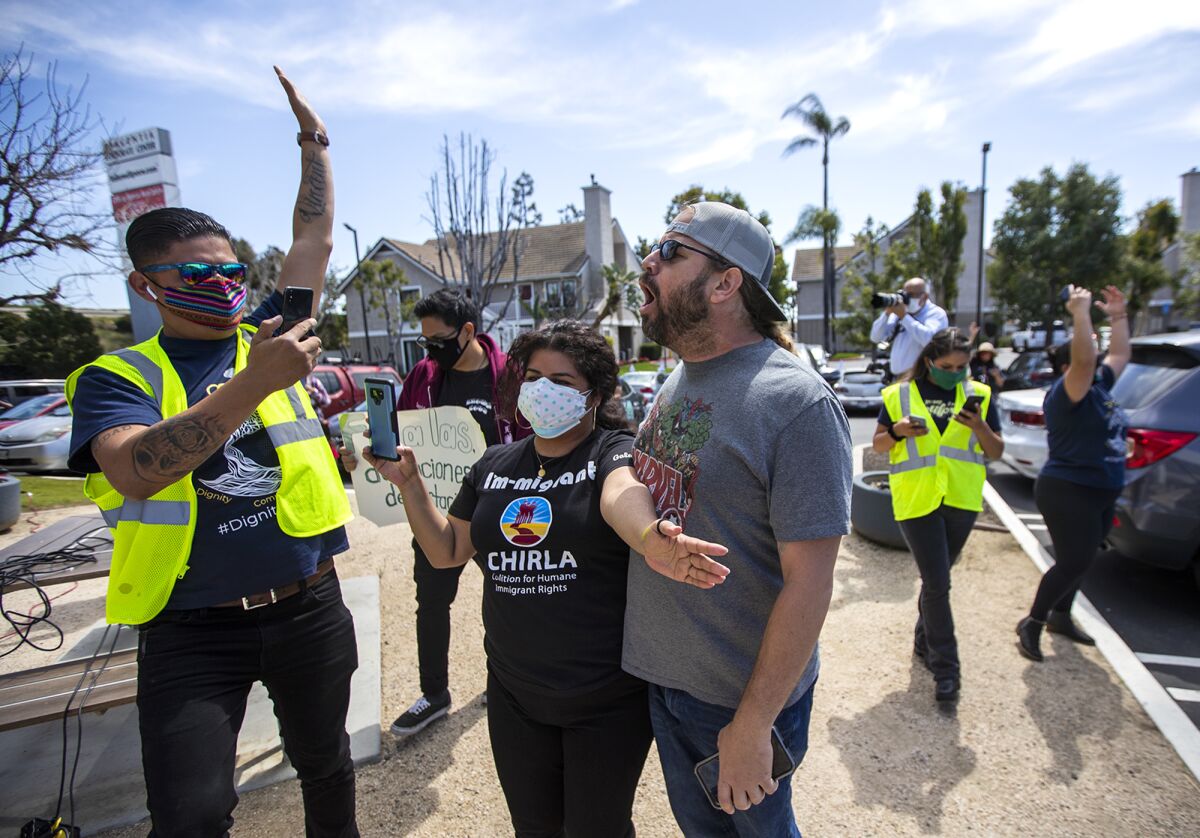A man confronts Victor Valladares, left, and Janeth Bucio with the Coalition for Humane Immigrant Rights.