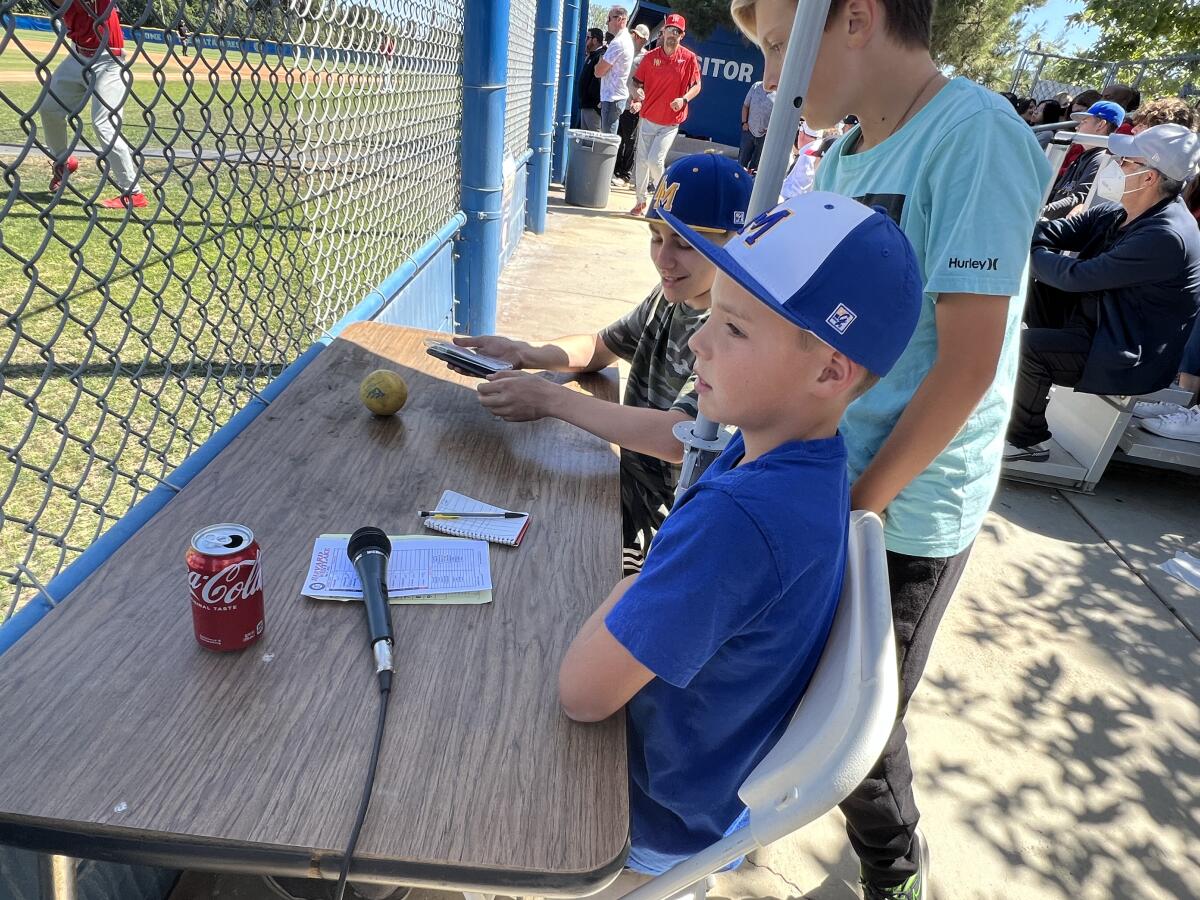 Ryan Zurn sits at a table watching a baseball game in between his announcing duties.