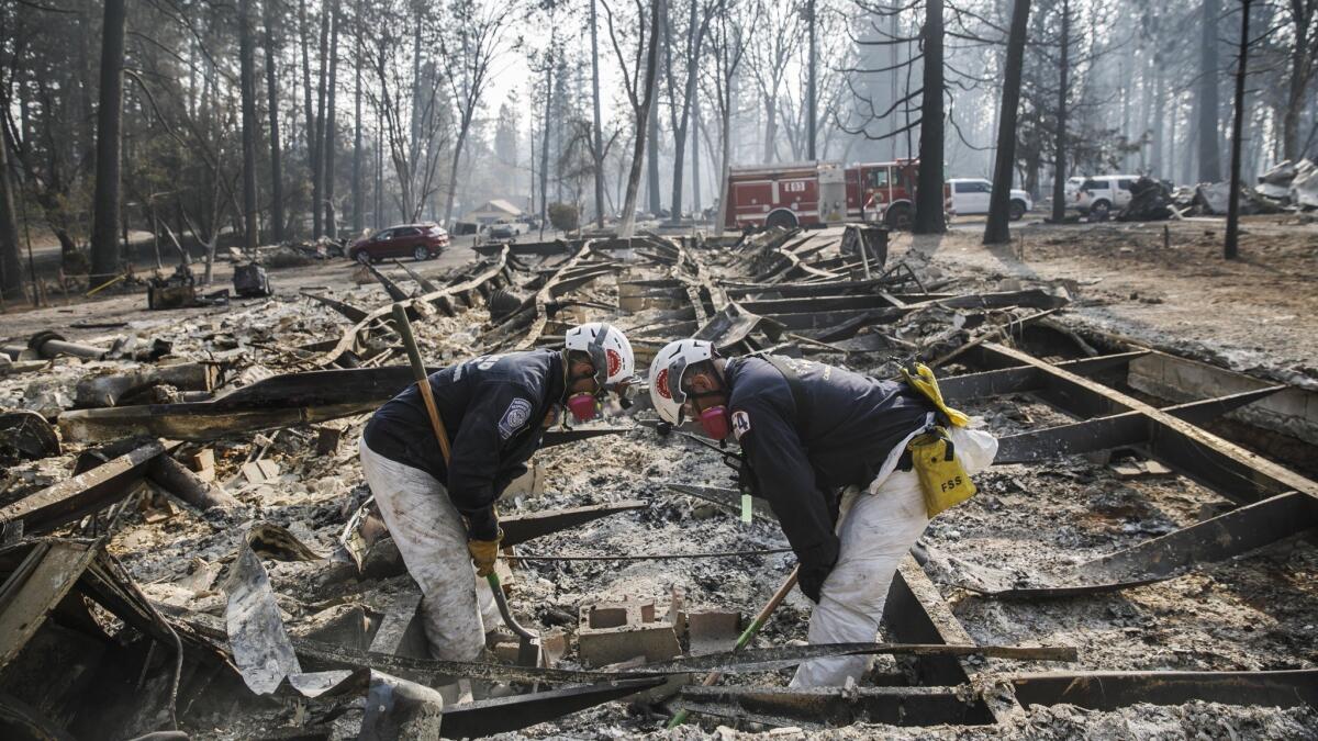 A search team Tuesday carefully scans an area for human remains after the Camp fire destroyed most of Paradise, Calif.