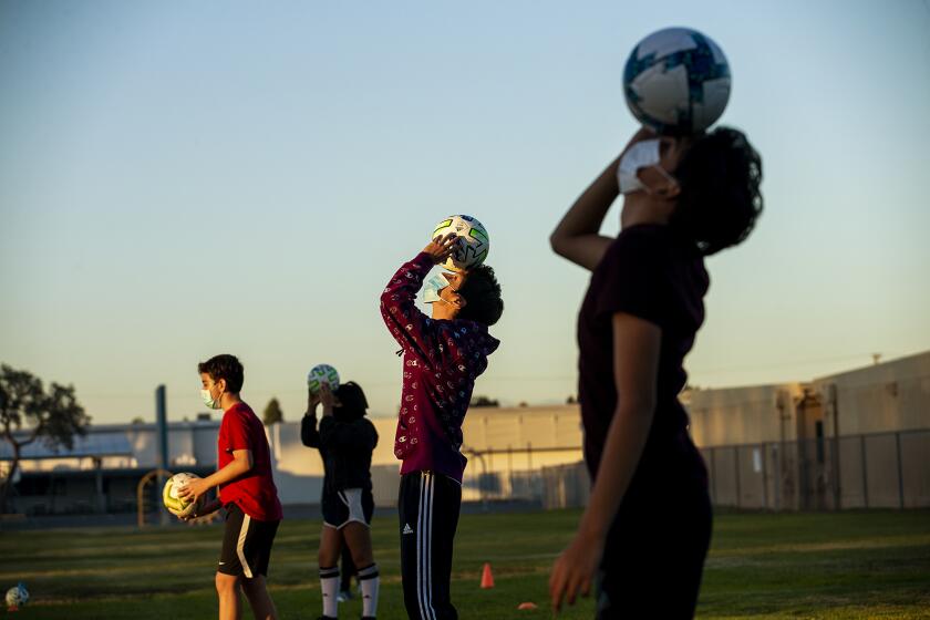 Andrew Arevalo, 12, left, Chelsea Vilchis, 13, Alex Vega, 16, and Isaias Maceda, 14, Estancia with brown and black jaceket at the end Angel Martinez, 15, right, participate in a soccer clinic put on by Orange County Soccer Club at the Costa Mesa-based SOY, Save Our Youth, on Tuesday, December 1.
