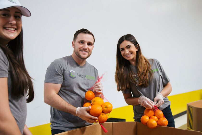 From left: Brittany Covell , Mark Ross and Megan Sheena prepare food packages at the San Diego Food Bank.