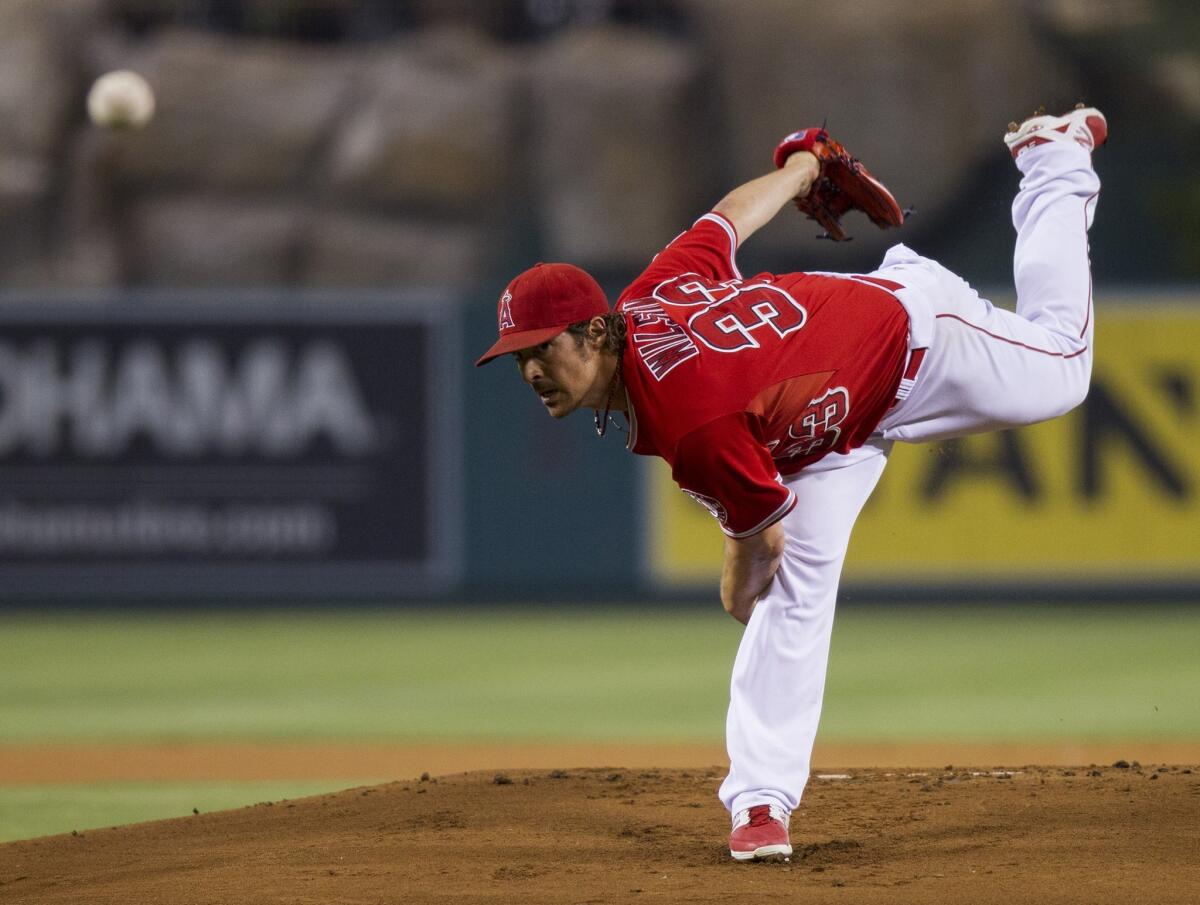 Angels starting pitcher C.J. Wilson follows through on a pitch against the Mariners in the first inning Wednesday night at Angel Stadium. Wilson gave up one hit and three walks in seven shutout innings.
