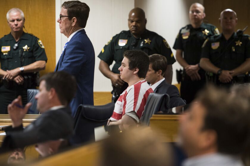 FILE - Austin Harrouff, center, wearing stripes, accused of brutally killing a Tequesta couple in 2016, appears Friday, Aug. 2, 2019, at the Martin County Courthouse in Stuart, Fla., as defense attorney Robert Watson, standing in front of Harrouff, asks Martin County Circuit Judge Sherwood Bauer Jr., to not allow video recording of a mental health evaluation to be conducted by a psychologist hired by the state. Harrouff, a former college student who killed a Florida couple in their garage six years earlier and then chewed on one victim’s face, is finally set to go on trial, Monday, Nov. 21, 2022. (Xavier Mascarenas/TCPalm.com via AP, File)