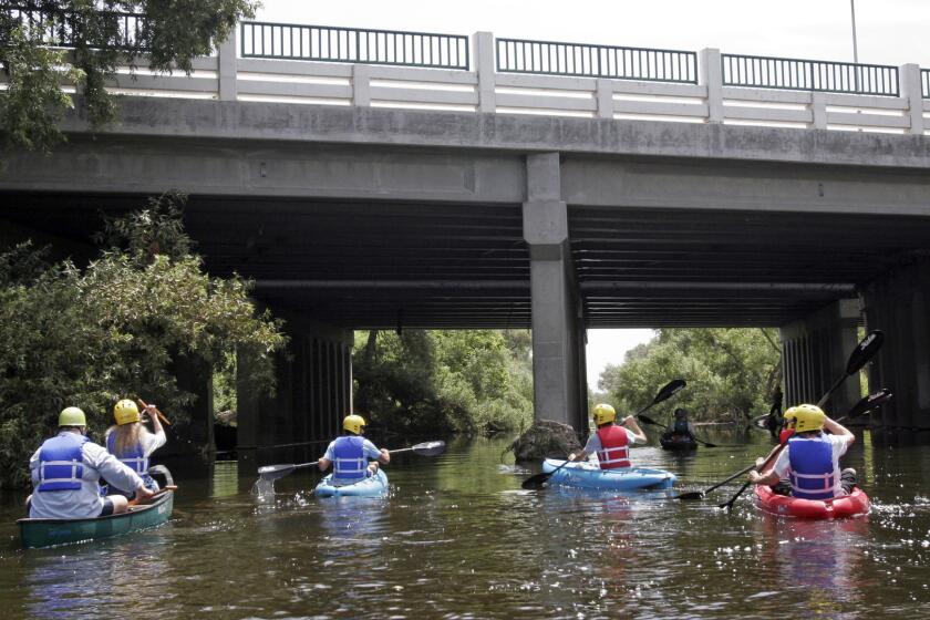 Kayakers paddle down the Los Angeles River in the Sepulveda Dam recreation area in Van Nuys.