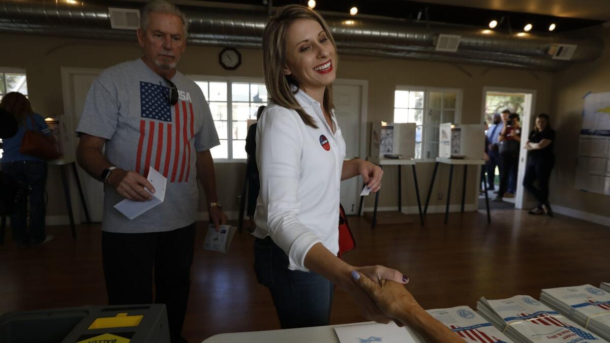Katie Hill, the Democrat running in the 25th Congressional District, shakes a poll worker’s hand as she votes in Agua Dulce.