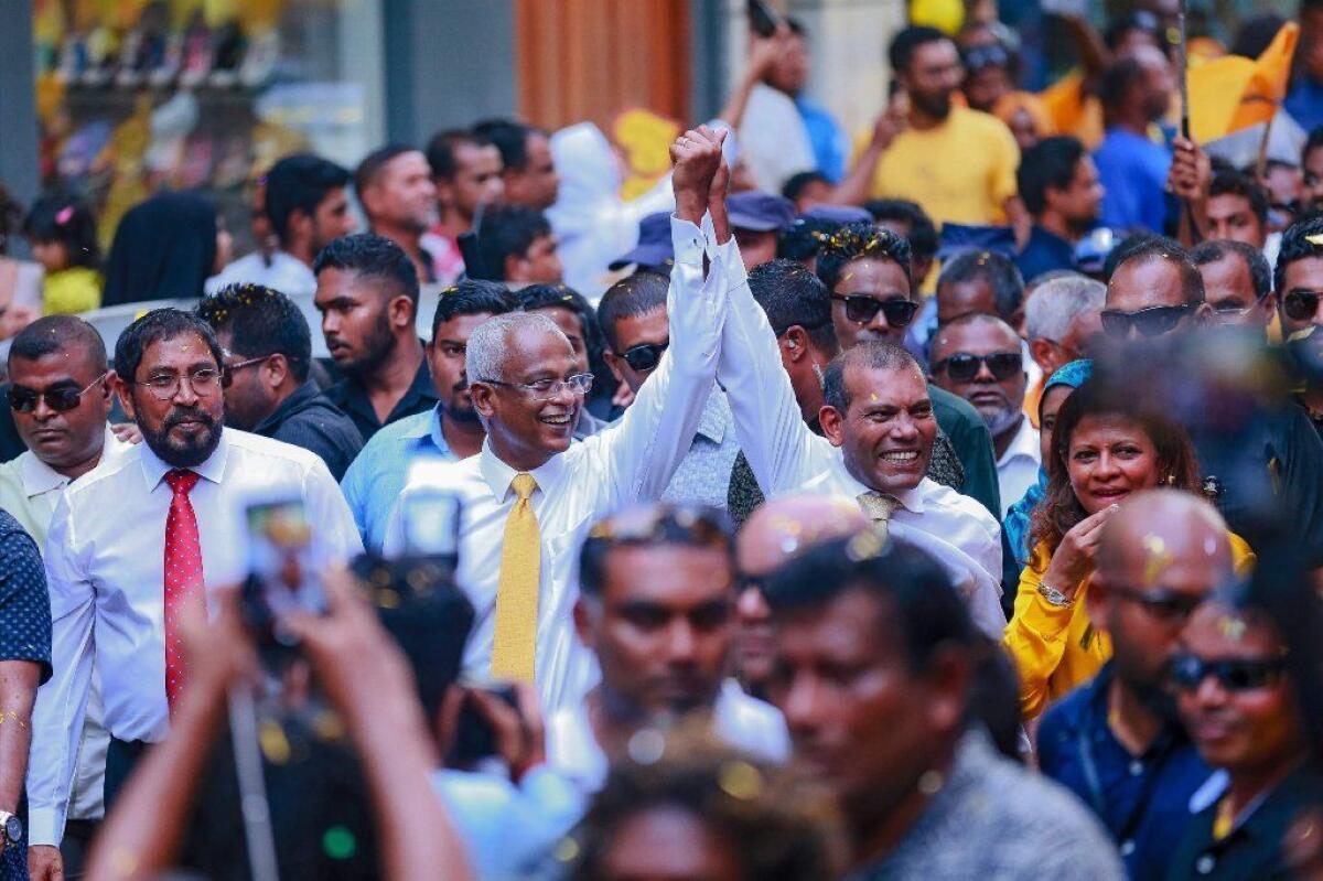 Former President Mohamed Nasheed, right, and President-elect Ibrahim Mohamed Solih walk to a rally in Male, Maldives, after Nasheed returned from exile.