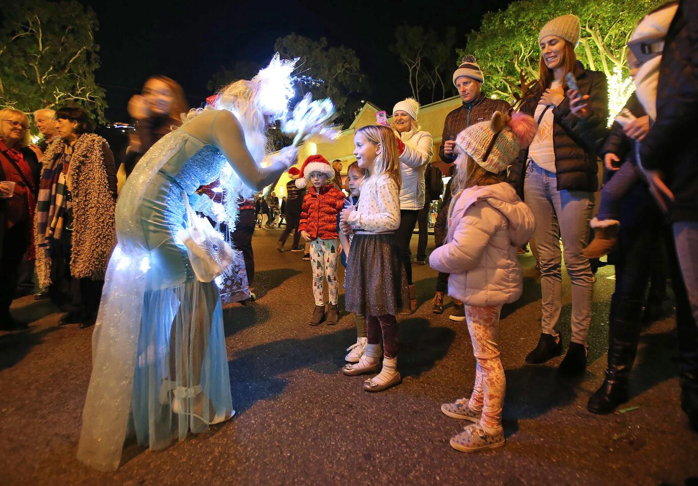 Kids and families gather around Christmas Wish Fairy Jessica Destefano, who blesses them with one wish each during the annual Hospitality Night 2018 on Forest Ave. in downtown Laguna Beach on Friday.