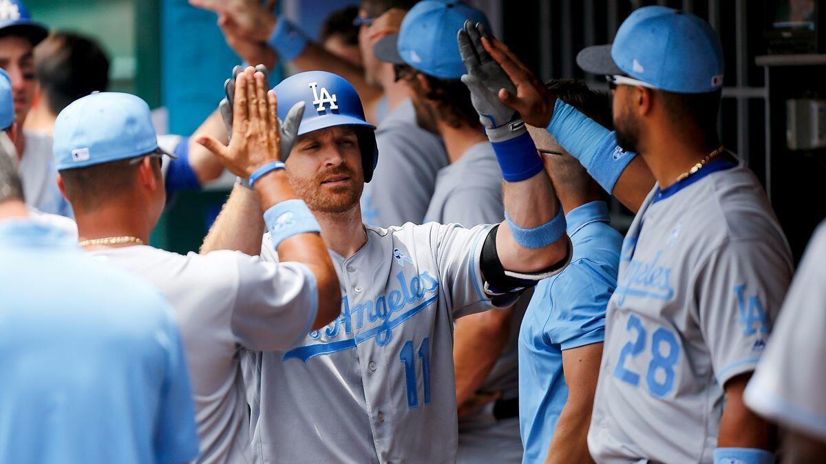 Dodgers' Logan Forsythe (11) celebrates with teammates after hitting a two-run home run in the third inning against the Cincinnati Reds.