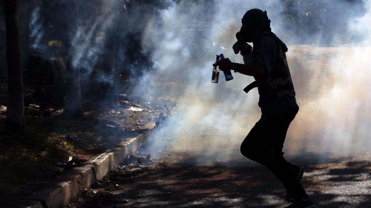 A protester runs through tear gas during a in Barquisimeto, a frequent site of anti-government unrest in Venezuela.