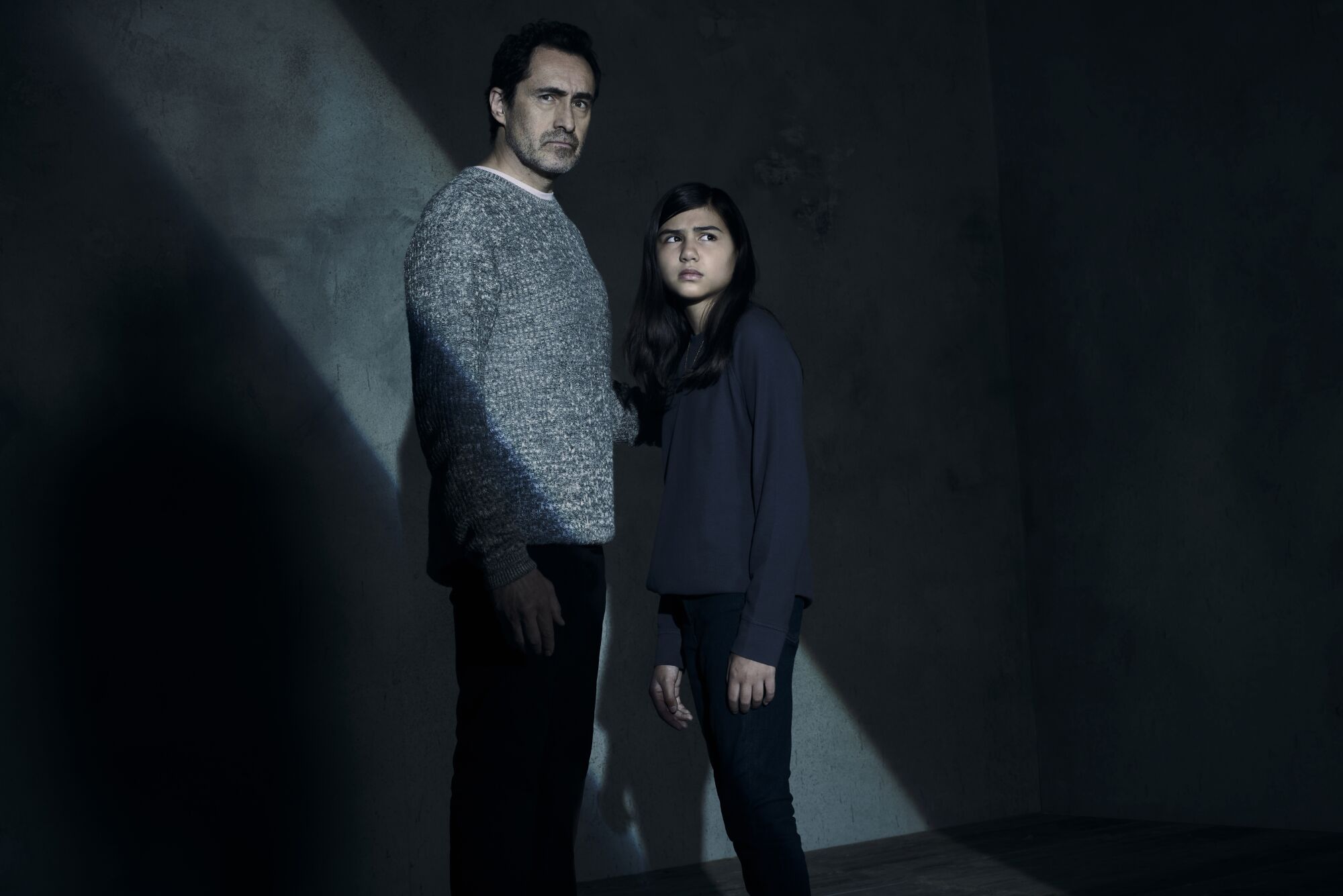 Actors portraying father and daughter stand side by side.