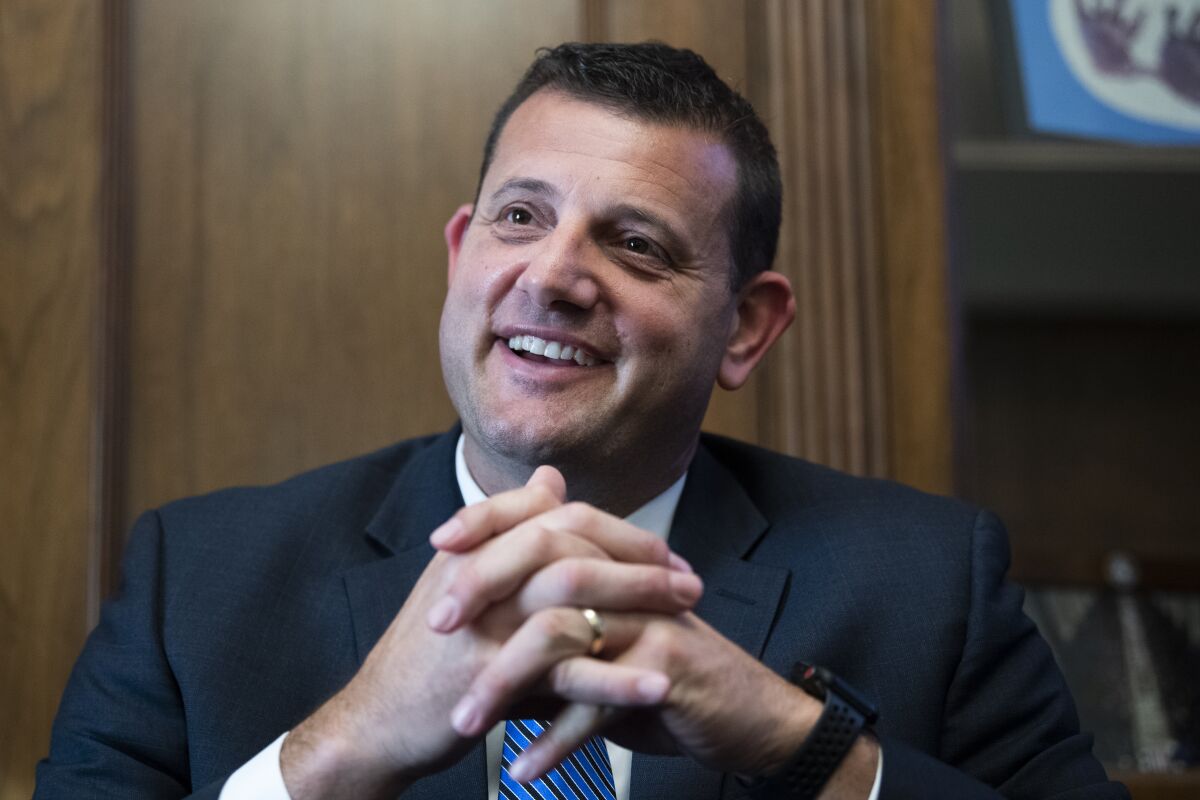A portrait of Rep. David Valadao smiling, with his fingers entwined