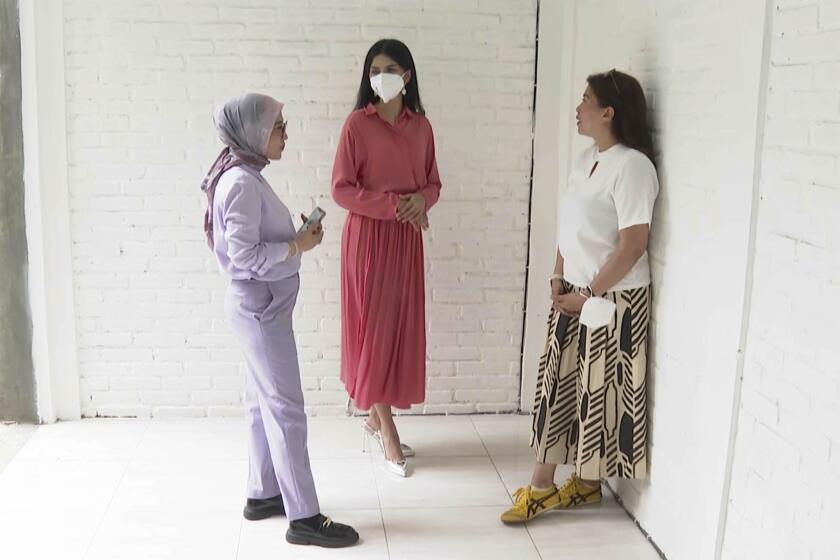 In this image made from video, contestant of Miss Universe Indonesia Priskila Ribka Jelita, center, talks with her mother, Maria Napitupulu, right, and lawyer Melisa Anggraini during an interview with the Associated Press Television in Jakarta, Indonesia, Tuesday, Aug. 15, 2023. The lawyer of a number of contestants of Miss Universe Indonesia pageant said Tuesday they have filed complaints with police, accusing local organizers of sexual harassment. (AP Photo/APTN)