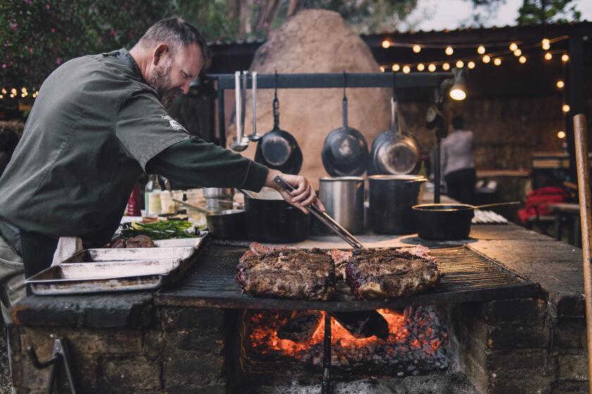 Chef-owner Drew Deckman cooks on his outdoor grill at Deckman’s en el Mogor.