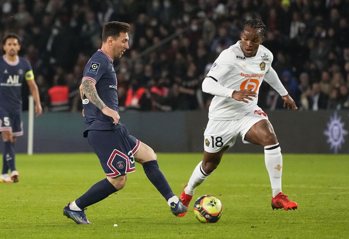 Lille's Renato Sanches, right, challenges for the ball with PSG's Lionel Messi during French League One soccer match between Paris Saint-Germain and Lille at the Parc des Princes stadium in Paris, France, Friday, Oct. 29, 2021. (AP Photo/Michel Euler)
