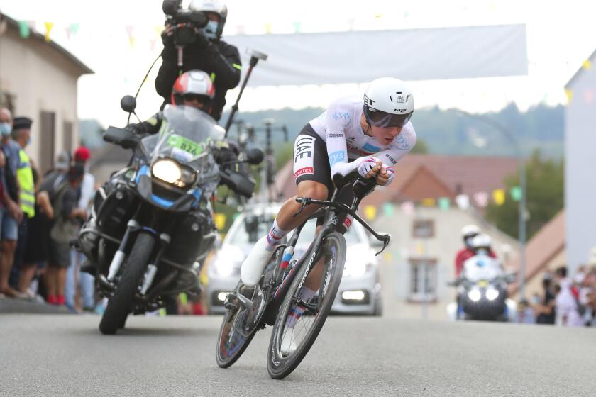 Slovenia's Tadej Pogacar wins and takes the overall leader's yellow jersey as he crosses the finish line of stage 20 of the Tour de France cycling race, an individual time trial over 36.2 kilometers (22.5 miles), from Lure to La Planche des Belles Filles, France, Saturday, Sept. 19, 2020. (AP Photo/Thibault Camus)