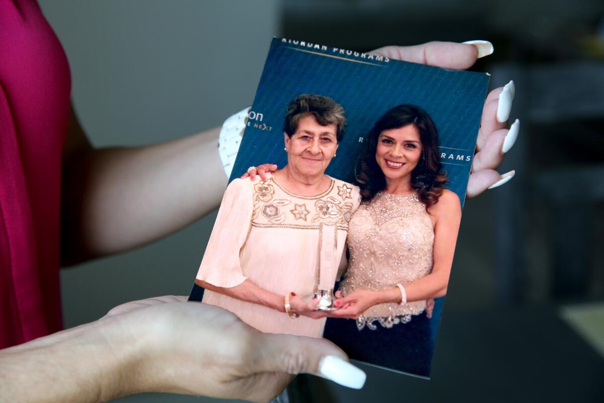 A close-up of a woman's hands holding a photo of two women.
