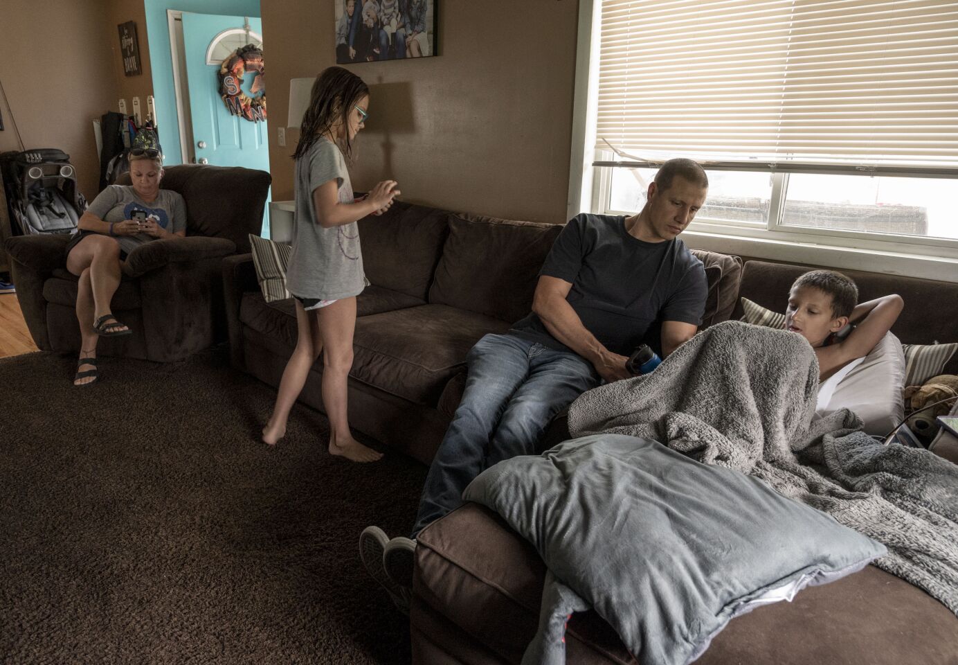 Carolyn, Brooklynn, John and Bo Macan relax at home. The family has health insurance through John's employer, but it's not nearly enough to meet Bo's needs.