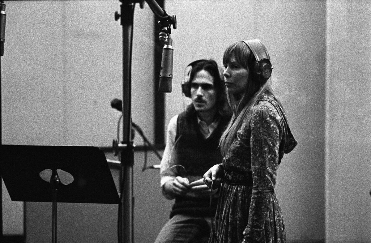 James Taylor, left, and Joni Mitchell in a recording studio, circa 1970. 