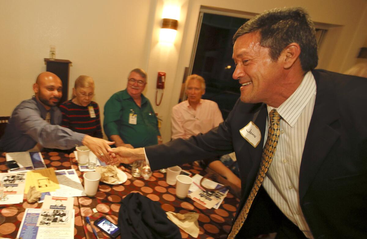 John Duran, right, candidate for the Los Angeles County Board of Supervisors, shakes hands with Mark Allen, a member of the Sun Valley area neighborhood council, during a campaign stop at the CBS Commissary known as Carla's Cafe in Studio City in April.
