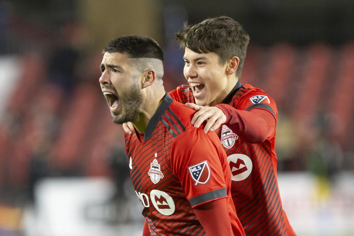 Toronto FC midfielder Alejandro Pozuelo, left, celebrates with teammate Kadin Chung after scoring his team's winning goal against Philadelphia Union during the second half of a MLS soccer game Saturday, April 16, 2022 in Toronto. (Chris Young/The Canadian Press)